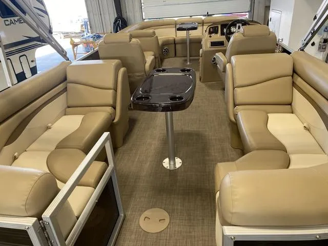 Slide: The Image of 2016 Bennington 24 SSRX pontoon boat interior with beige seating and central table. - 18