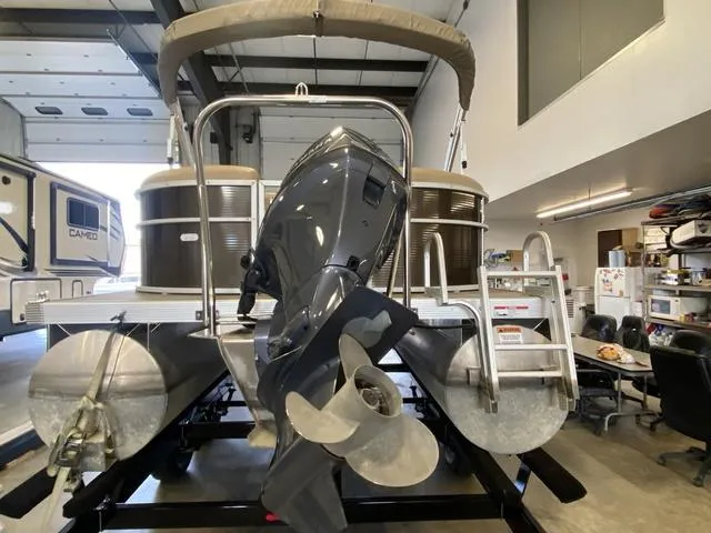 Slide: The Image of 2016 Bennington 24 SSRX pontoon boat with outboard motor in a garage setting. - 3