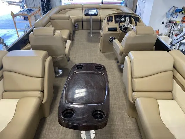 Slide: The Image of 2016 Bennington 24 SSRX pontoon boat interior with beige seating and central table. - 6