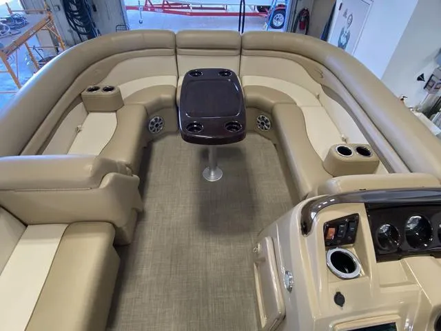 Slide: The Image of 2016 Bennington 24 SSRX boat interior with beige seating and central table. - 7