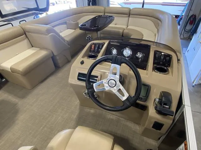 Slide: The Image of 2016 Bennington 24 SSRX boat interior with beige seating and steering console. - 9
