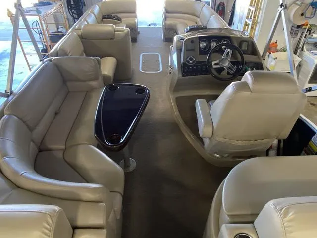 Slide: The Image of 2012 Bennington 25 RCW-I/O pontoon boat interior with beige seating and sleek dashboard. - 12