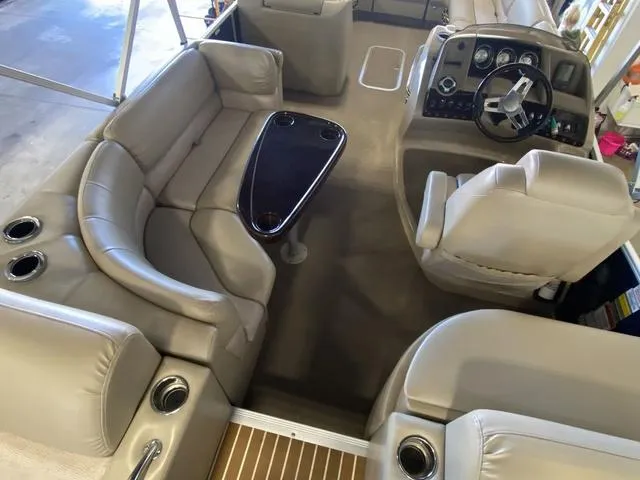 Slide: The Image of 2012 Bennington 25 RCW-I/O boat interior with beige seating and steering console. - 13