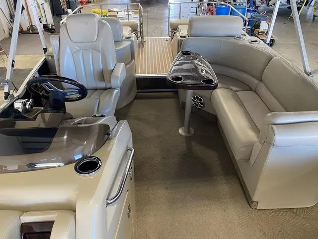 Slide: The Image of 2012 Bennington 25 RCW-I/O boat interior with beige seating and steering console. - 14