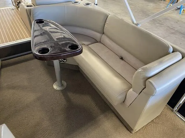 Slide: The Image of 2012 Bennington 25 RCW-I/O boat interior with beige seating and a dark wood table. - 15