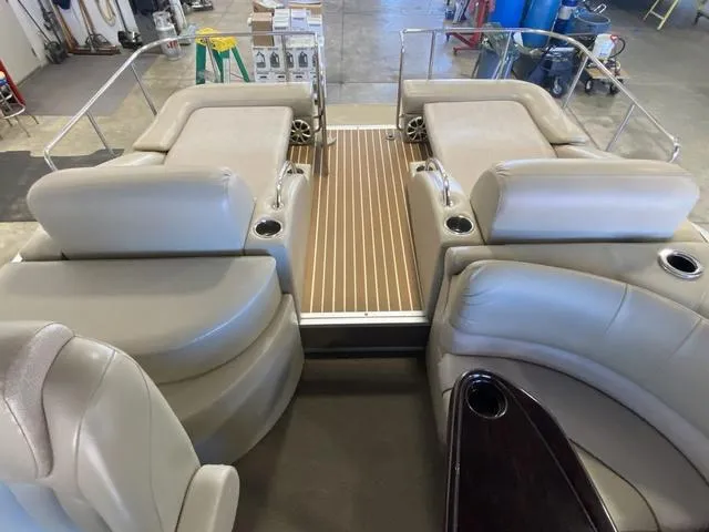Slide: The Image of 2012 Bennington 25 RCW-I/O boat interior with beige seating and wood flooring. - 8