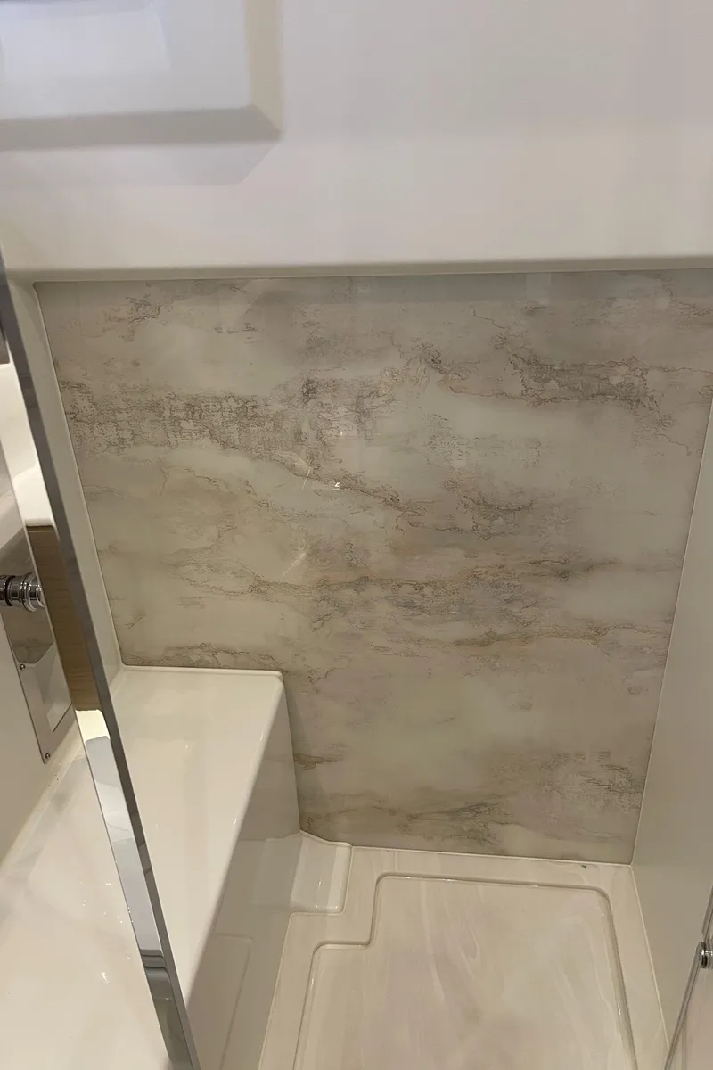 Slide: The Image of Interior of 2025 Jeanneau DB/43 OB boat, featuring modern bathroom design with marble accents. - 22