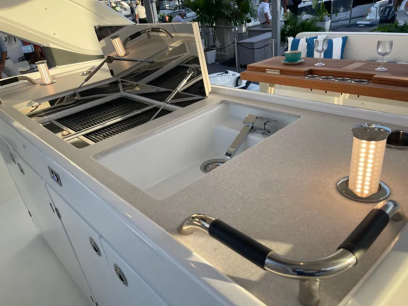 Slide: The Image of 2025 Jeanneau DB/43 OB yacht kitchen with sink, grill, and elegant lighting. - 4