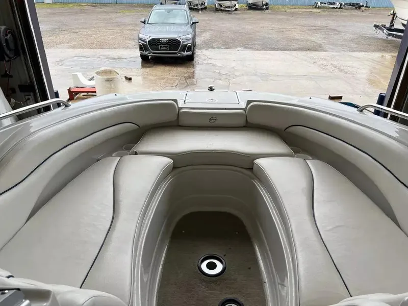 Slide: The Image of 2003 Crownline 230 BR boat interior with spacious seating, parked Audi in background. - 16