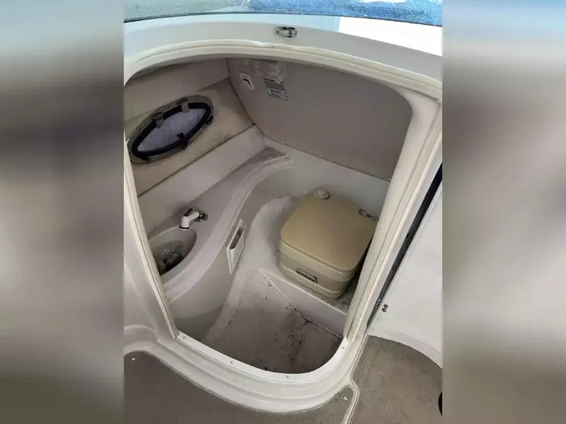 Slide: The Image of 2003 Crownline 230 BR boat interior with compact bathroom and toilet. - 17