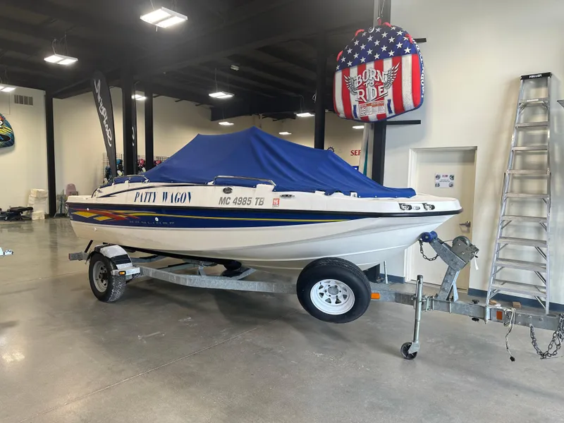 Slide: The Image of 2007 Bayliner 197 boat with blue cover on trailer in showroom. - 1