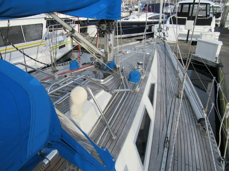 Slide: The Image of 1981 Sweden Yachts 41 sailboat deck with blue covers and marina background. - 12