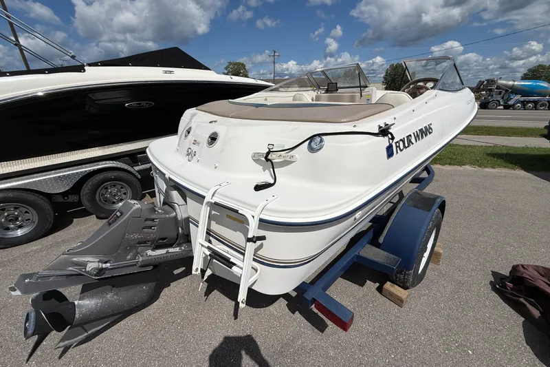 Slide: The Image of 1997 Four Winns 170 Horizon Ski/Fish boat on trailer, parked outdoors under a cloudy sky. - 3
