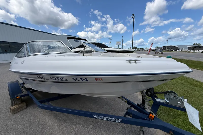 The Image of 1997 Four Winns 170 Horizon Ski/Fish boat on trailer, parked outdoors under a cloudy sky. - 1