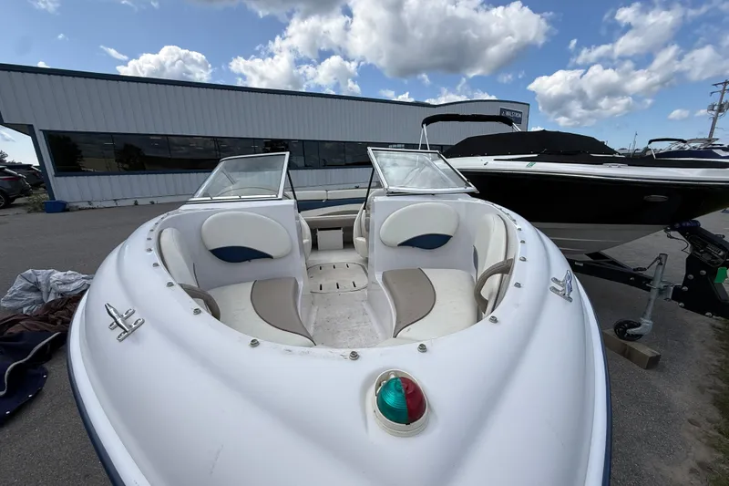 Slide: The Image of 1997 Four Winns 170 Horizon Ski/Fish boat with open bow seating, parked outdoors. - 4
