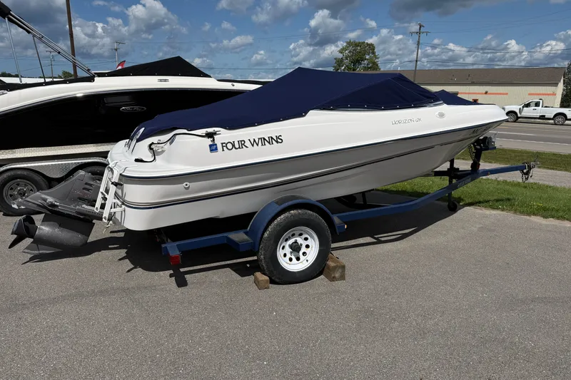 Slide: The Image of 1997 Four Winns 170 Horizon Ski/Fish boat on trailer, covered, parked outdoors. - 2