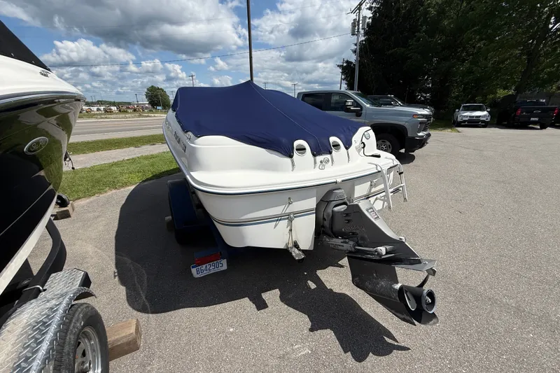 Slide: The Image of 1997 Four Winns 170 Horizon Ski/Fish boat with blue cover, parked on a trailer. - 5