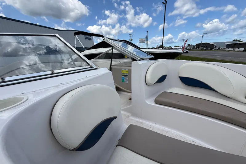 Slide: The Image of 1997 Four Winns 170 Horizon Ski/Fish boat interior with white and blue seating under a cloudy sky. - 12