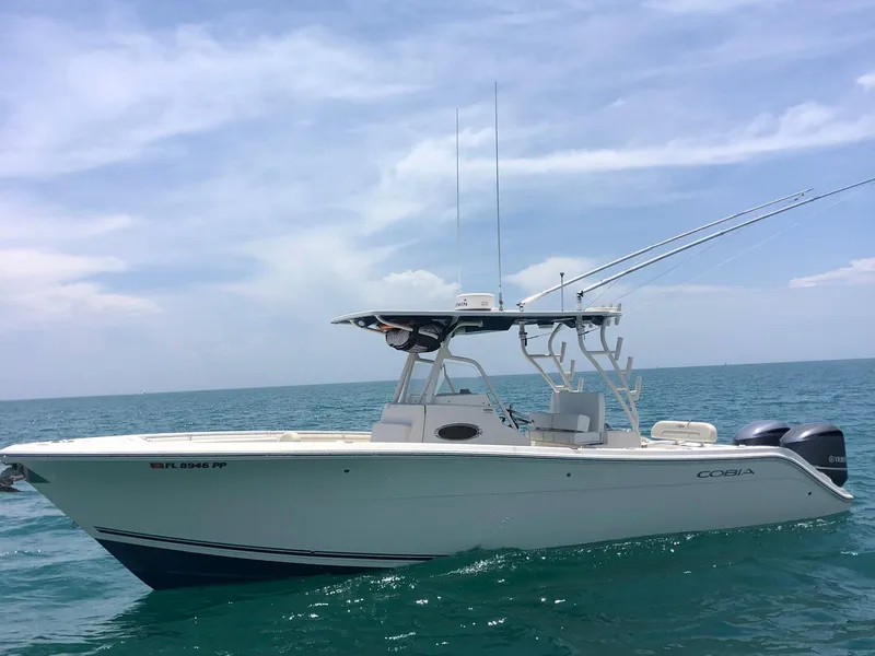 Slide: The Image of 2014 Cobia 296 Center Console boat on open water under clear sky. - 13