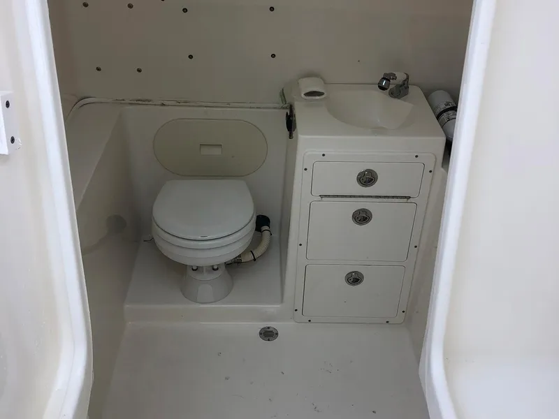 Slide: The Image of 2014 Cobia 296 Center Console boat bathroom with toilet and sink. - 6