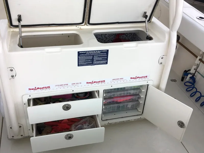 Slide: The Image of 2014 Cobia 296 Center Console storage compartments with open drawers and tackle boxes. - 7