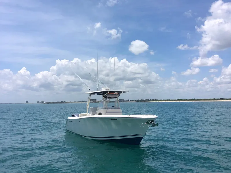 Slide: The Image of 2014 Cobia 296 Center Console boat on calm ocean waters under a blue sky. - 9