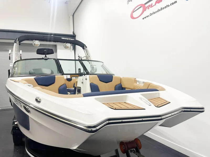 Slide: The Image of 2022 MasterCraft NXT24 boat with sleek design and spacious seating in showroom. - 1