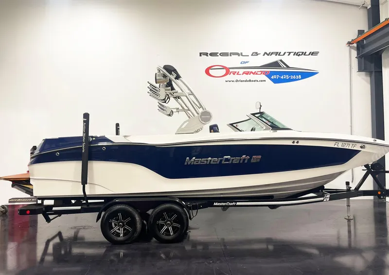 Slide: The Image of 2022 MasterCraft NXT24 boat on trailer in showroom. - 2