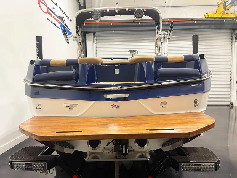 Slide: The Image of 2022 MasterCraft NXT24 boat interior with tan and blue seating, teak-style flooring. - 6
