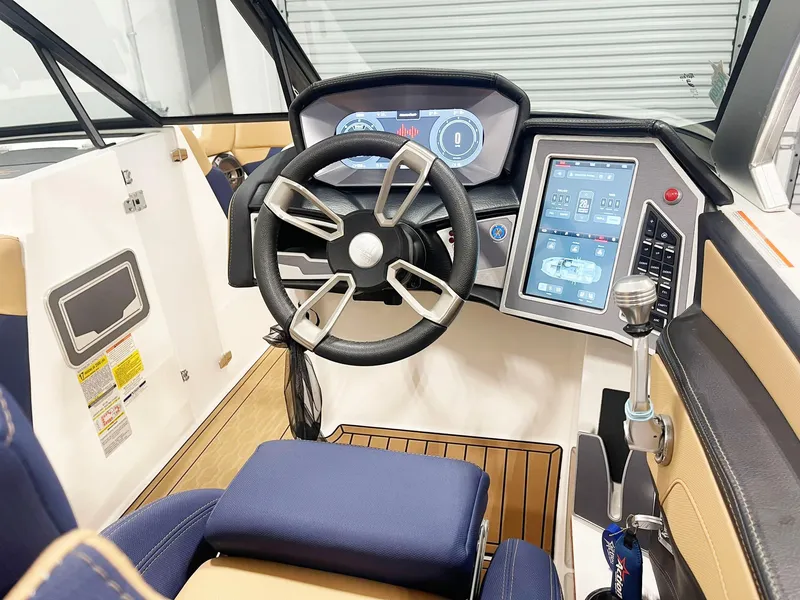 Slide: The Image of Interior of 2022 MasterCraft NXT24 boat with tan and navy seating, wood flooring. - 8