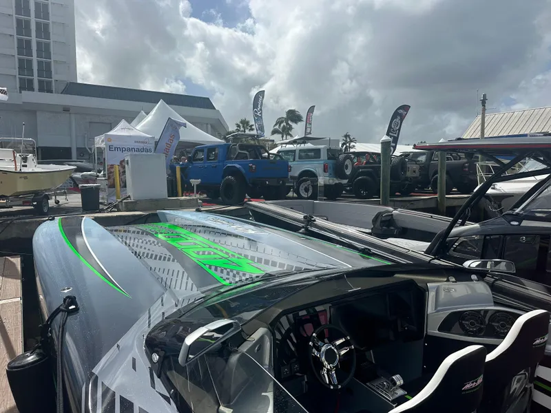 Slide: The Image of 2025 Nor-Tech 4000 Supercat at outdoor boat show with vehicles and tents. - 12