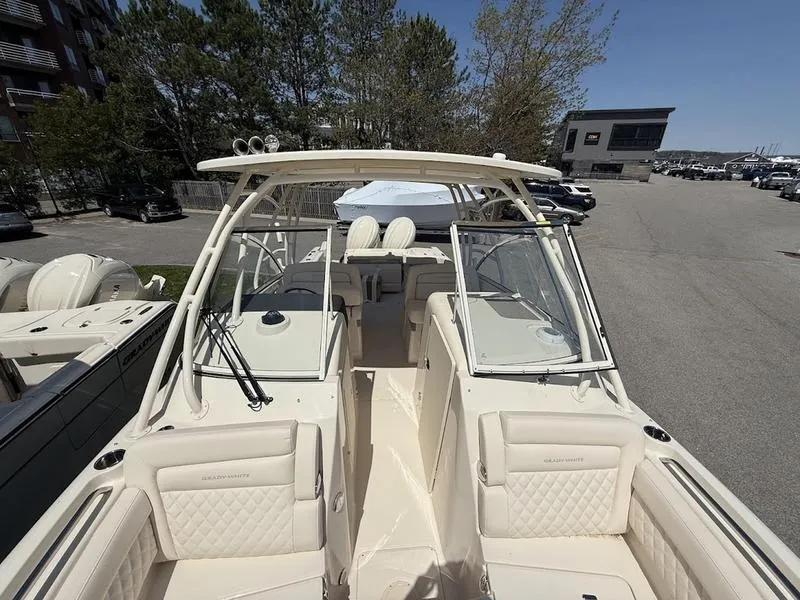 Slide: The Image of 2025 Grady-White Freedom 235 boat with spacious seating and modern design in a marina setting. - 13