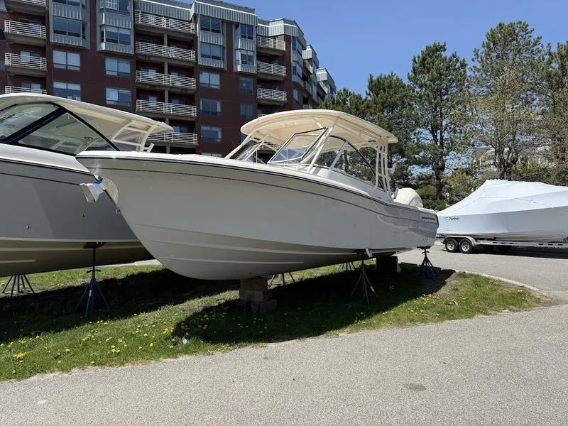 Slide: The Image of 2025 Grady-White Freedom 235 boat displayed outdoors near residential buildings. - 6