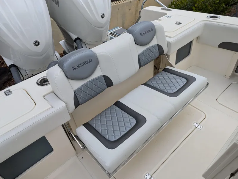 Slide: The Image of 2025 Blackwood 290LXF boat seating with quilted cushions and dual outboard motors. - 22
