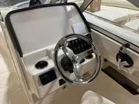 Slide: The Image of 2025 Grady-White Freedom 235 boat dashboard with steering wheel and controls. - 4