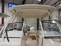 Slide: The Image of 2025 Grady-White Freedom 235 boat interior, showcasing seating and helm in a showroom. - 6