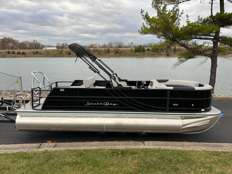 Slide: The Image of 2025 South Bay LE 222 UL pontoon boat by a lake, featuring sleek black design. - 4