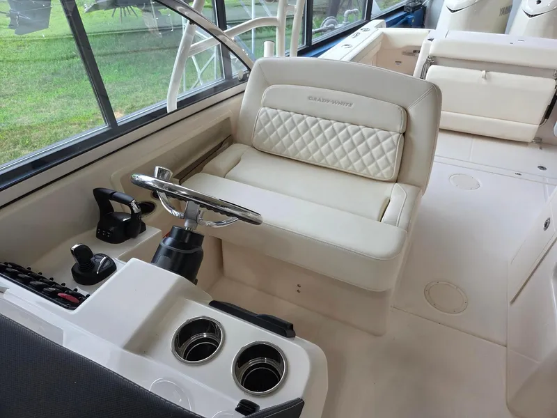 Slide: The Image of 2025 Grady-White Freedom 285 boat interior with steering wheel and cushioned seating. - 12
