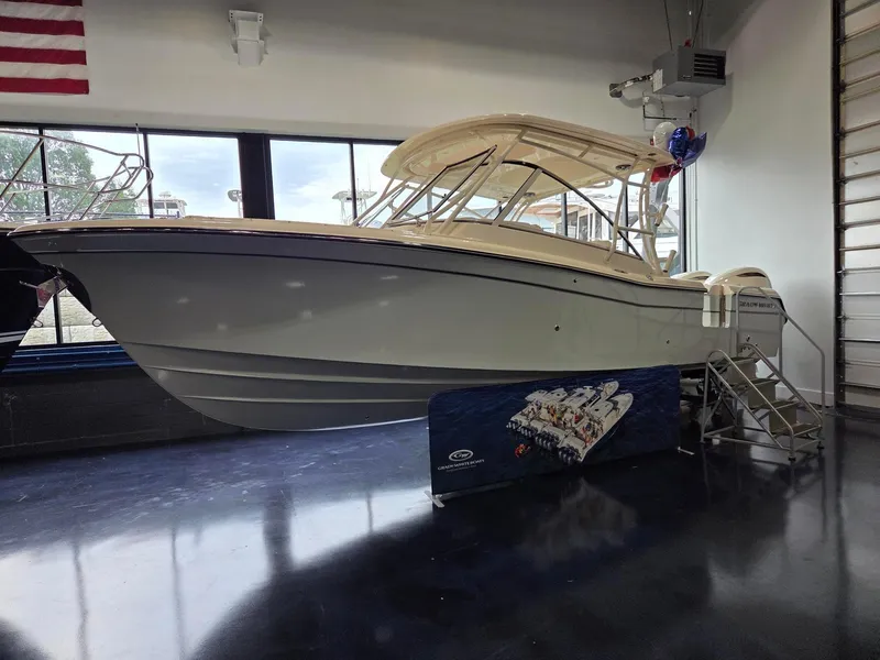 The Image of 2025 Grady-White Freedom 285 boat displayed indoors with American flag backdrop. - 2