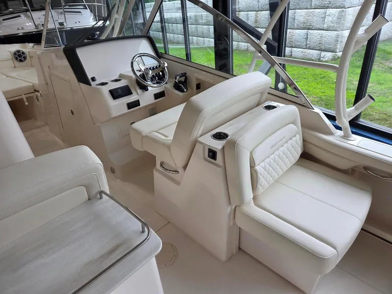 Slide: The Image of 2025 Grady-White Freedom 285 boat interior with white seating and modern helm controls. - 8