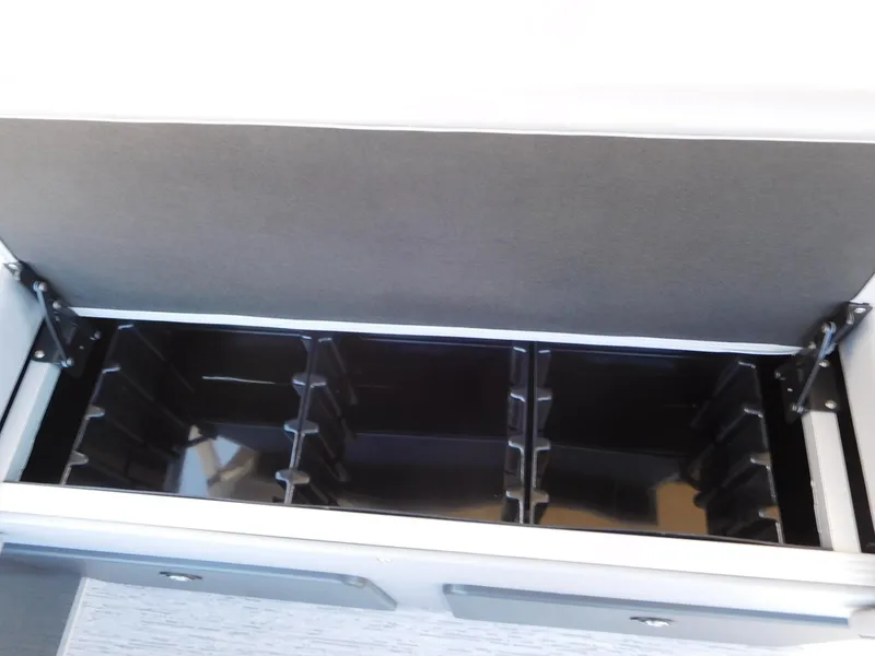 Slide: The Image of Storage compartment in 2025 Bennington 23 SS boat, featuring organized dividers. - 8
