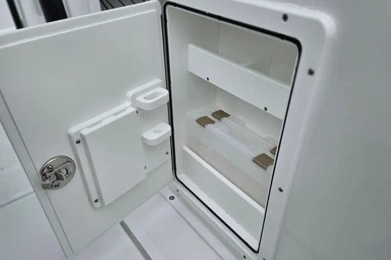 Slide: The Image of Open storage compartment on 2026 Sea Hunt Gamefish 25 boat, featuring organized shelves. - 10