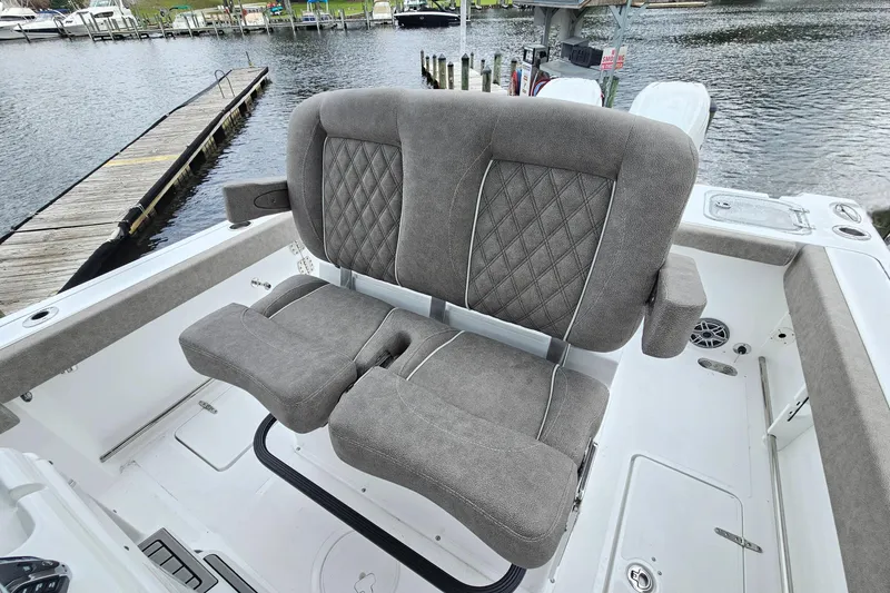 Slide: The Image of 2026 Sea Hunt Gamefish 25 boat with plush, diamond-stitched seating by the water. - 14