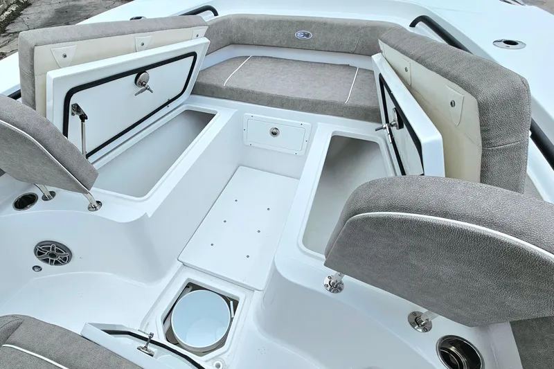 Slide: The Image of 2026 Sea Hunt Gamefish 25 boat interior with open storage compartments and cushioned seating. - 19