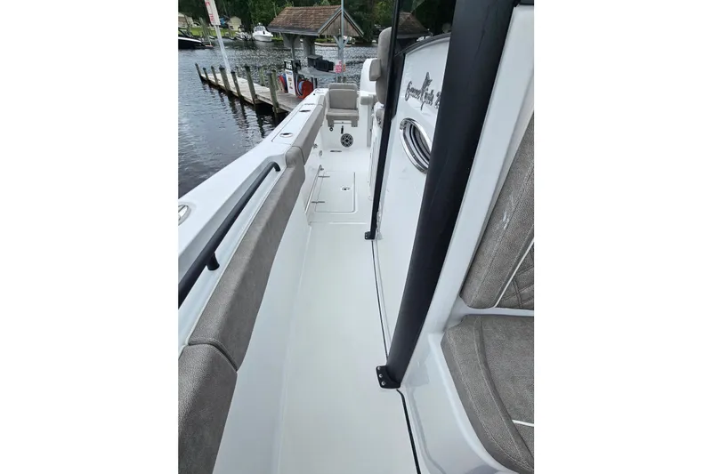 Slide: The Image of 2026 Sea Hunt Gamefish 25 boat interior with seating and dock view. - 24