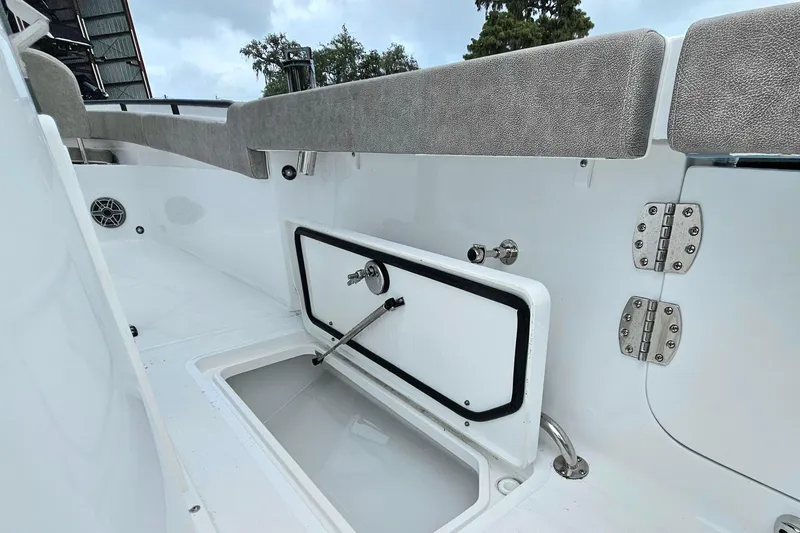 Slide: The Image of 2026 Sea Hunt Gamefish 25 boat interior with storage compartment and cushioned seating. - 26