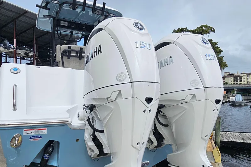 Slide: The Image of 2026 Sea Hunt Gamefish 25 with dual Yamaha 150 engines docked by the water. - 27