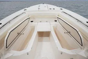 Slide: The Image of 2025 Grady-White Canyon 306 boat interior with open storage compartments on calm water. - 10