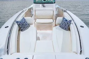 Slide: The Image of 2025 Grady-White Canyon 306 boat interior with cushioned seating and decorative pillows. - 4