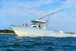 Slide: The Image of 2025 Grady-White Canyon 306 boat cruising on open water under a clear sky. - 9